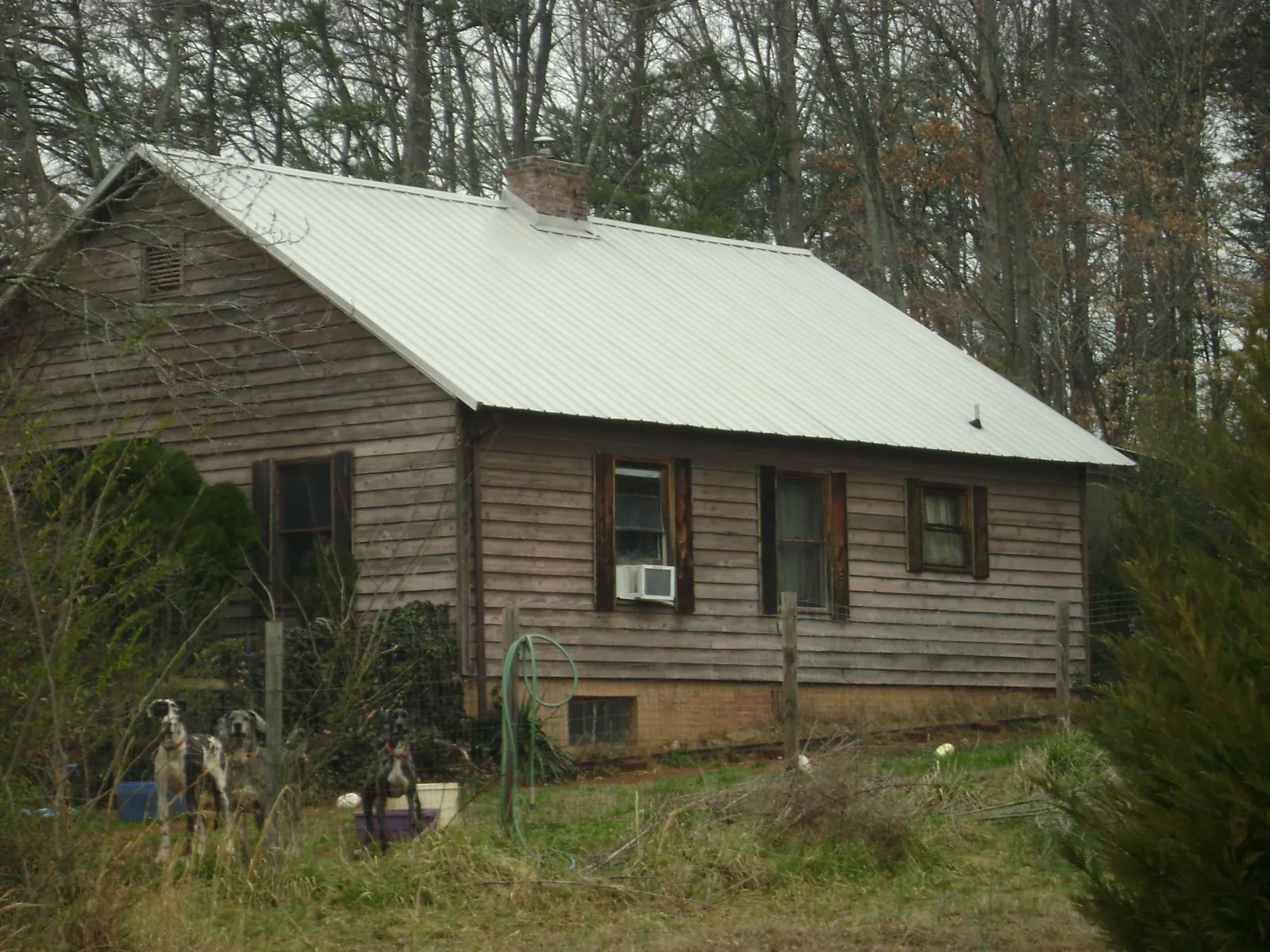 White metal roof on an old wood sided farmhouse, from a Metal Roof Installation job in Mission